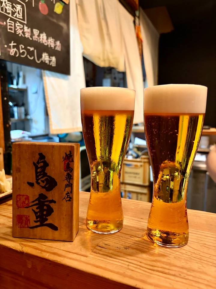 カウンターに置かれた「鳥重」の木札と生ビール